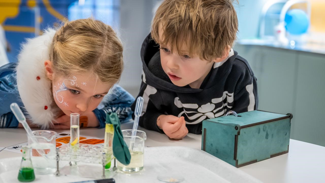 Två barn gör häxan Agata Densitatas spannande kemiexperiment på Curiosum
