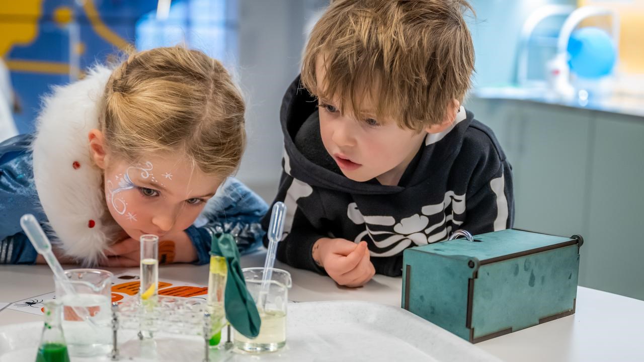 Två barn gör häxan Agata Densitatas spannande kemiexperiment på Curiosum