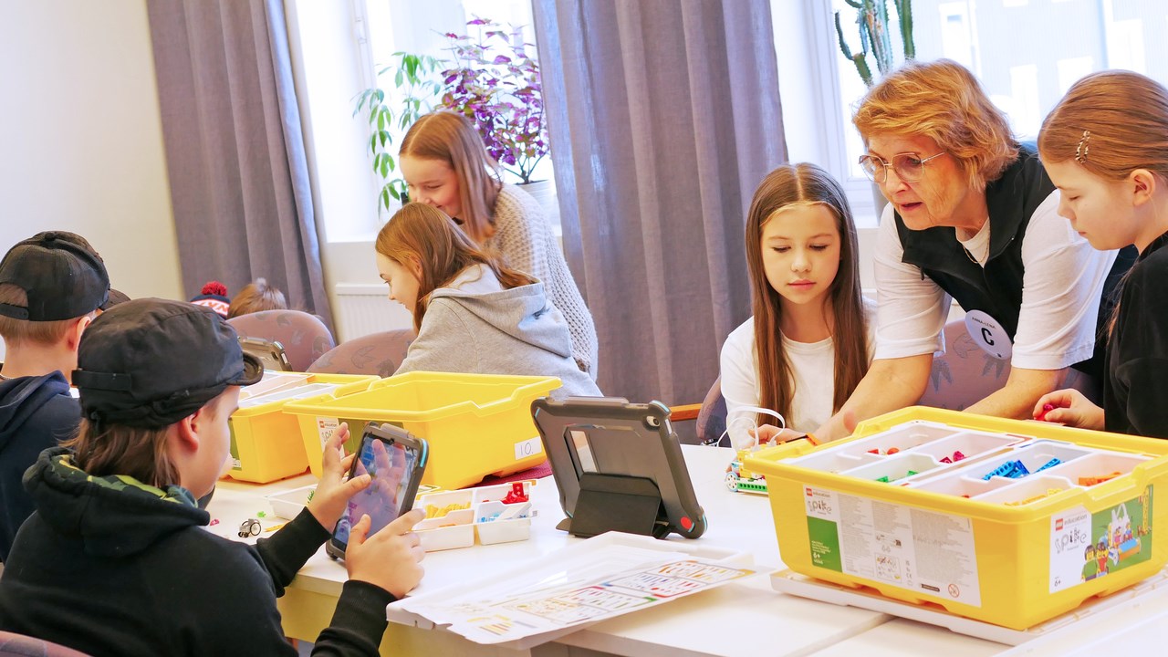 Pedagog från Curiosum instruerar elever hur de programmerar en LEGO-robot.