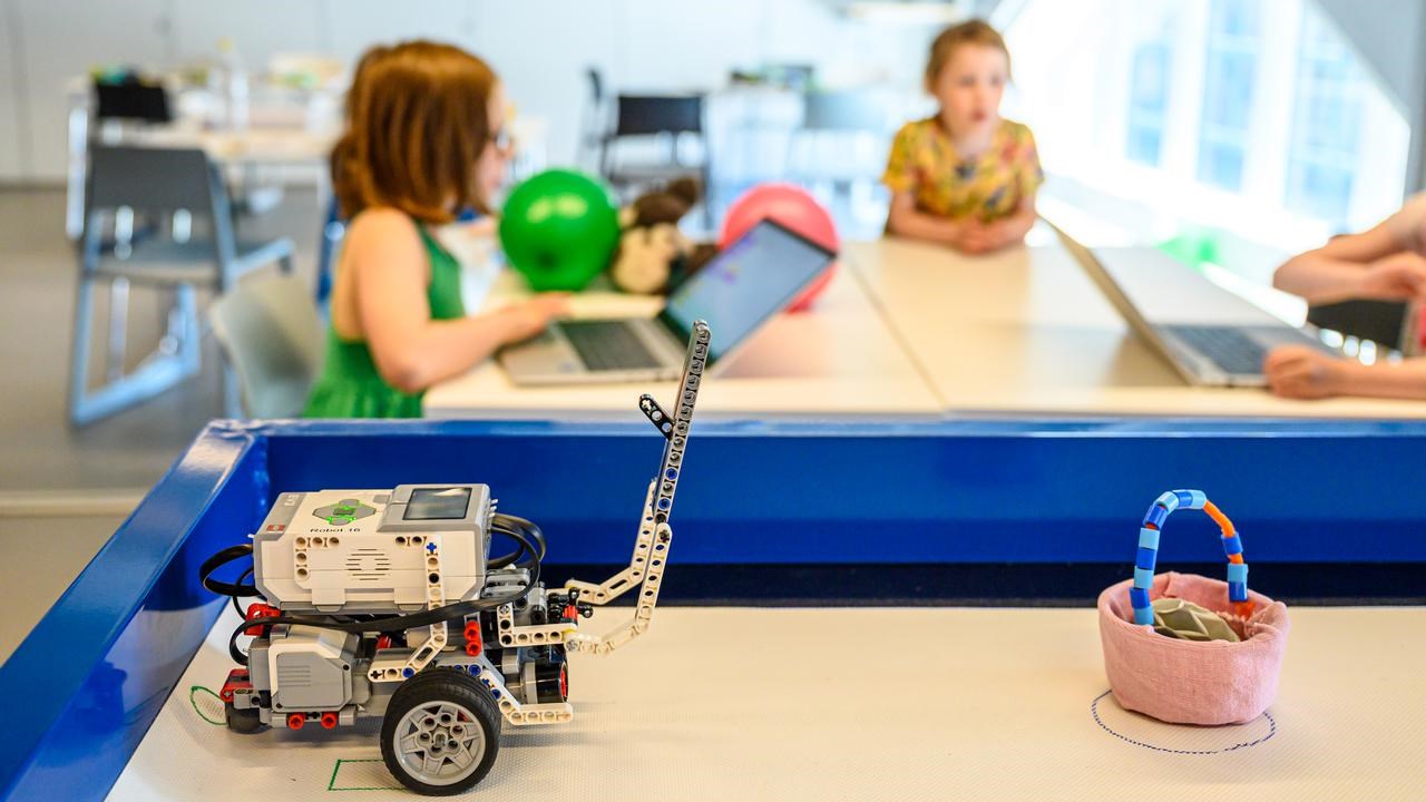 WeDo Legorobot i Curiosums tekniklabb. I bakgrunden tre barn.