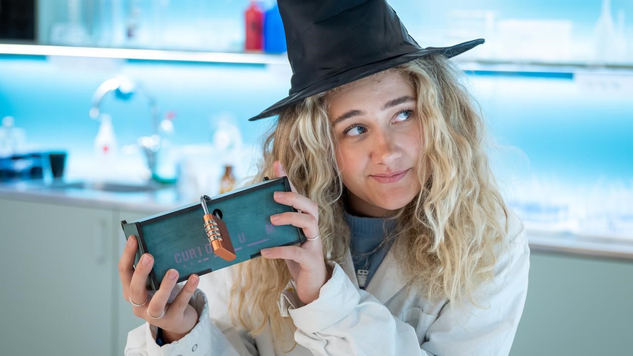 Häxan Agata Densitata i CUriosums kemilabb, skakar på sin magiska låda