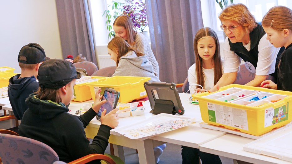 Pedagog från Curiosum instruerar elever hur de programmerar en LEGO-robot.