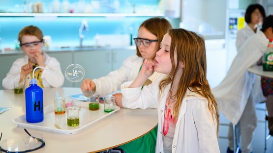 Barn experimenterar med såpbubblor i kemilabbet.