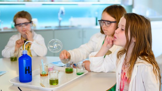 Barn experimenterar med såpbubblor i kemilabbet.