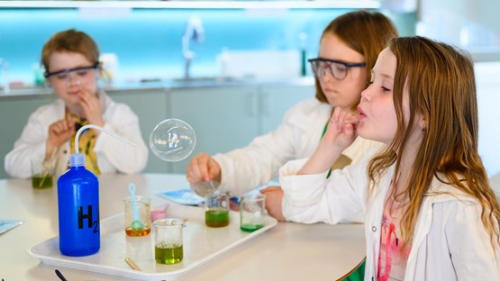 Barn experimenterar med såpbubblor i kemilabbet.