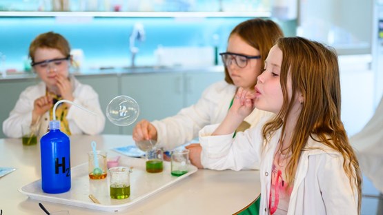 Barn experimenterar med såpbubblor i kemilabbet.