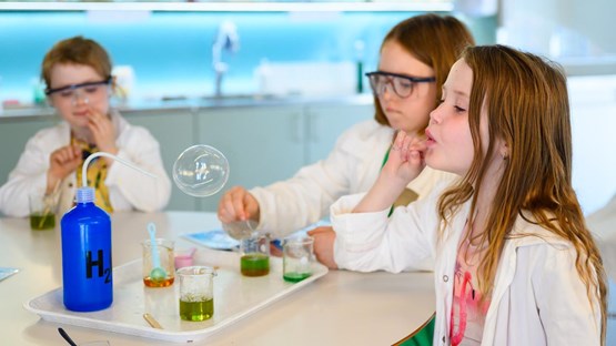 Barn experimenterar med såpbubblor i kemilabbet.