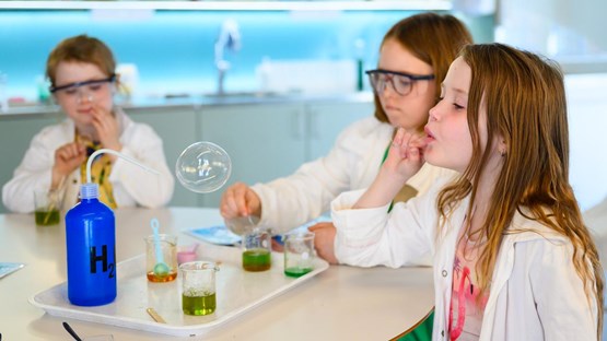 Barn experimenterar med såpbubblor i kemilabbet.
