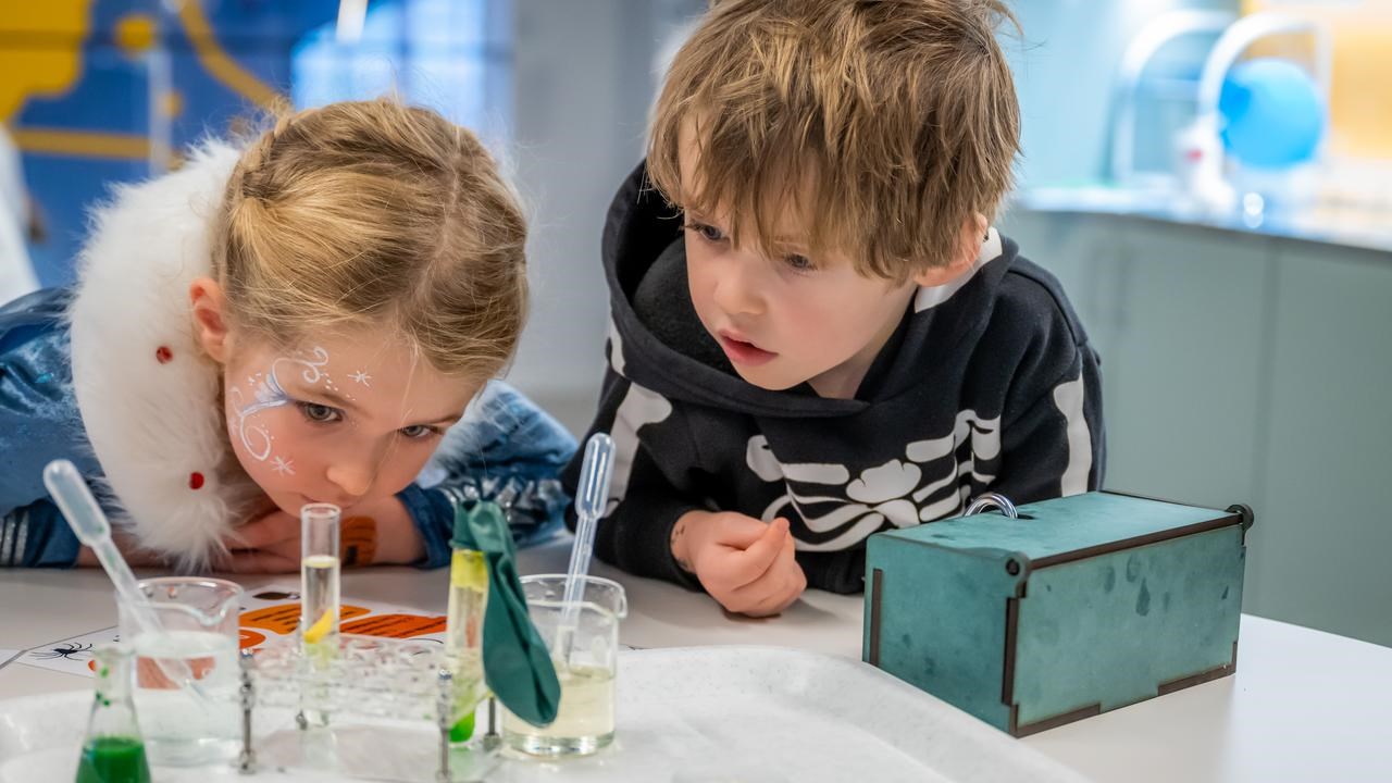 Två barn gör häxan Agata Densitatas spannande kemiexperiment på Curiosum