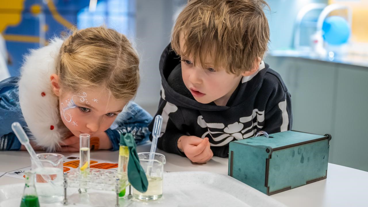 Två barn gör häxan Agata Densitatas spannande kemiexperiment på Curiosum