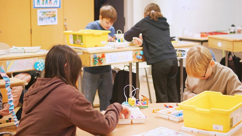 Fyra barn programmerar LEGO-robotar.