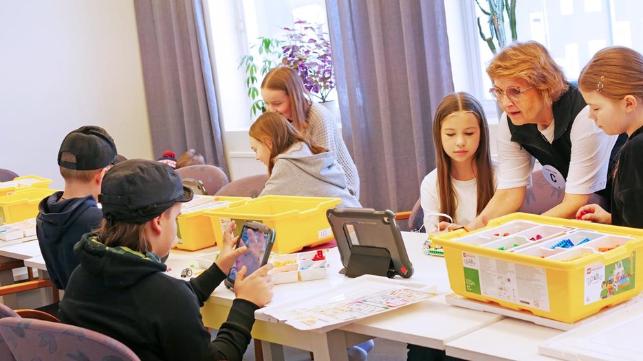Pedagog från Curiosum instruerar elever hur de programmerar en LEGO-robot.