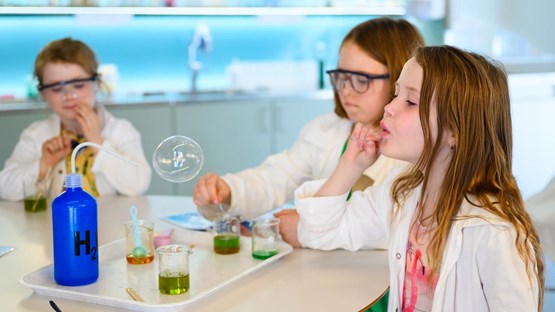Barn experimenterar med såpbubblor i kemilabbet.