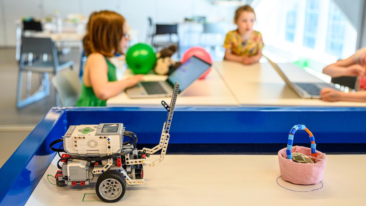 WeDo Legorobot i Curiosums tekniklabb. I bakgrunden tre barn.