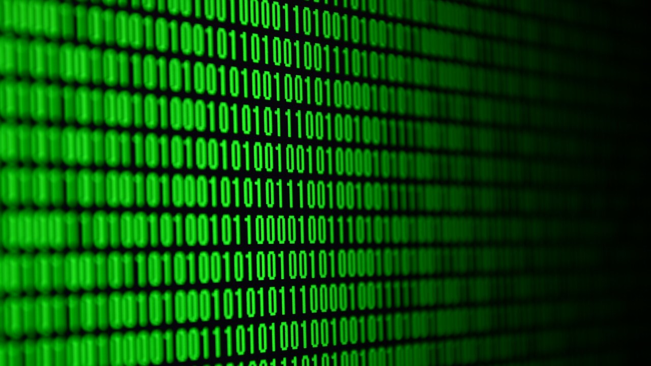 Bild p&aring; datorsk&auml;rm med bin&auml;r kod som lyser gr&ouml;n.