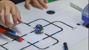Two small children are programming an ozobot