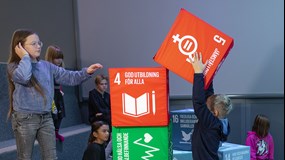 Two children build a tower with cubes with the global goals