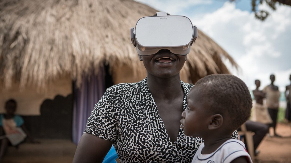 Kvinna tittar i VR -glasögon. Från flyktingläger i Uganda.