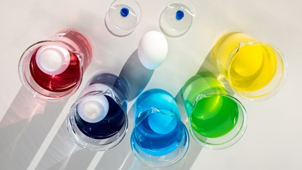 Eggs in glasses with liquid in different colors