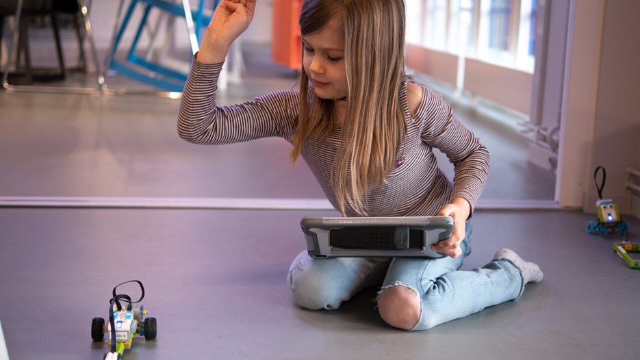 flicka programmerar en wedo robot